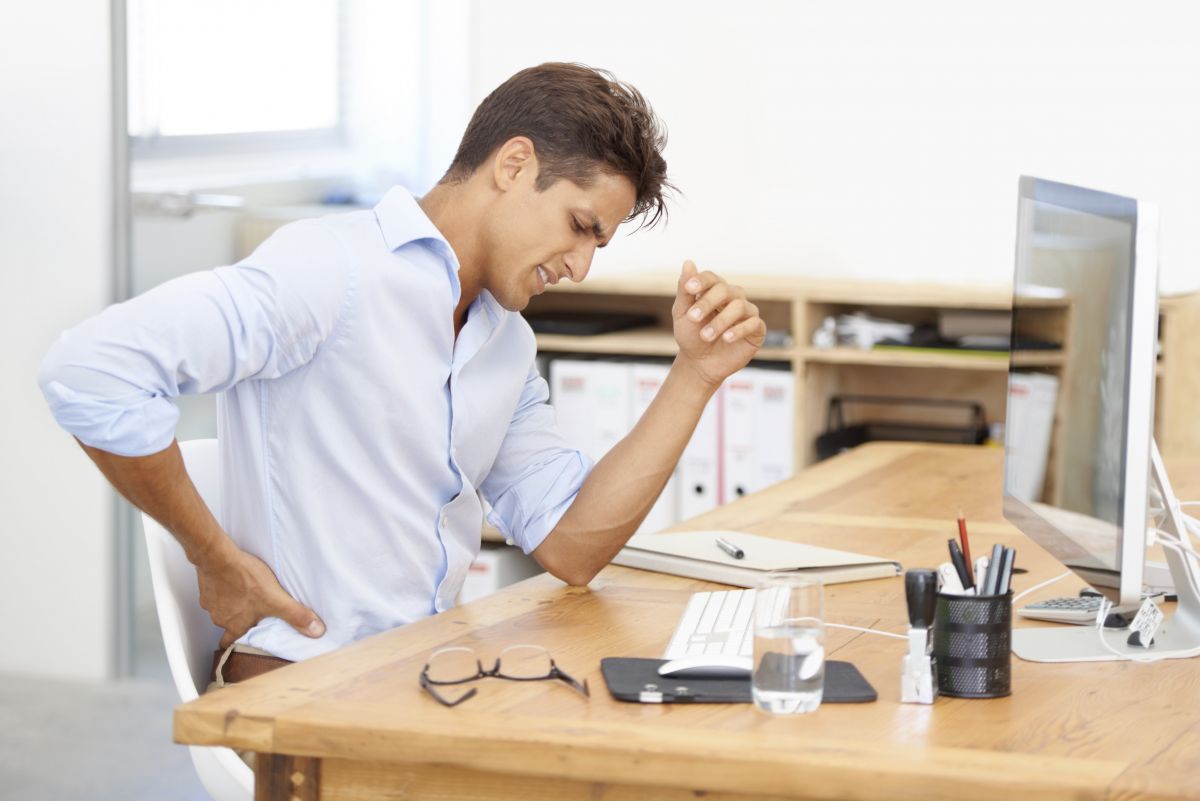 Male at desk with back pain